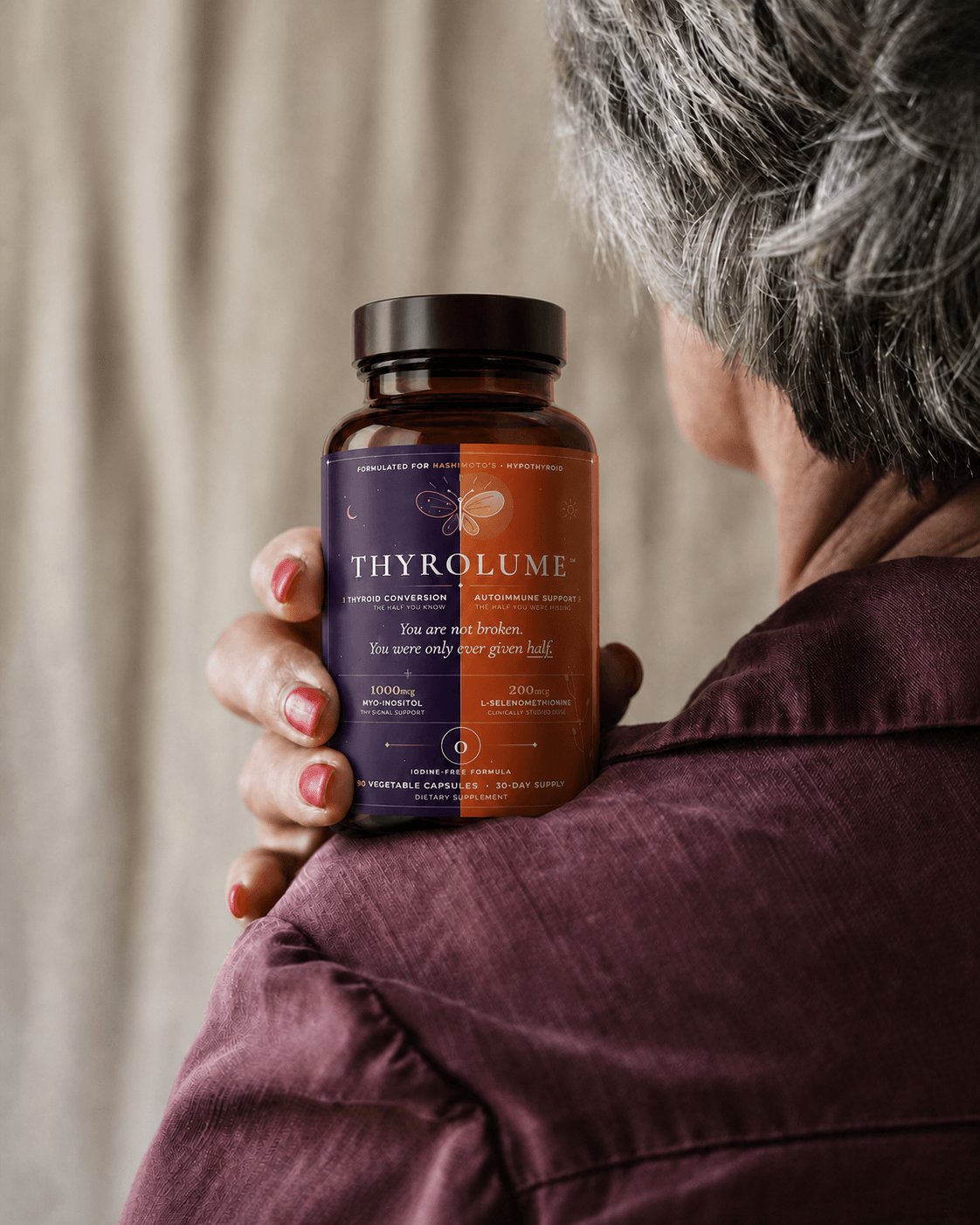 Woman holding an iodine-free thyroid support supplement for Hashimoto’s